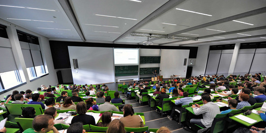 Students sit in a lecture hall in the seminar building at the Campus North.